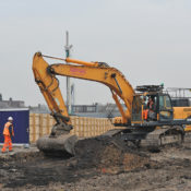 A digger clearing the top layer of earth